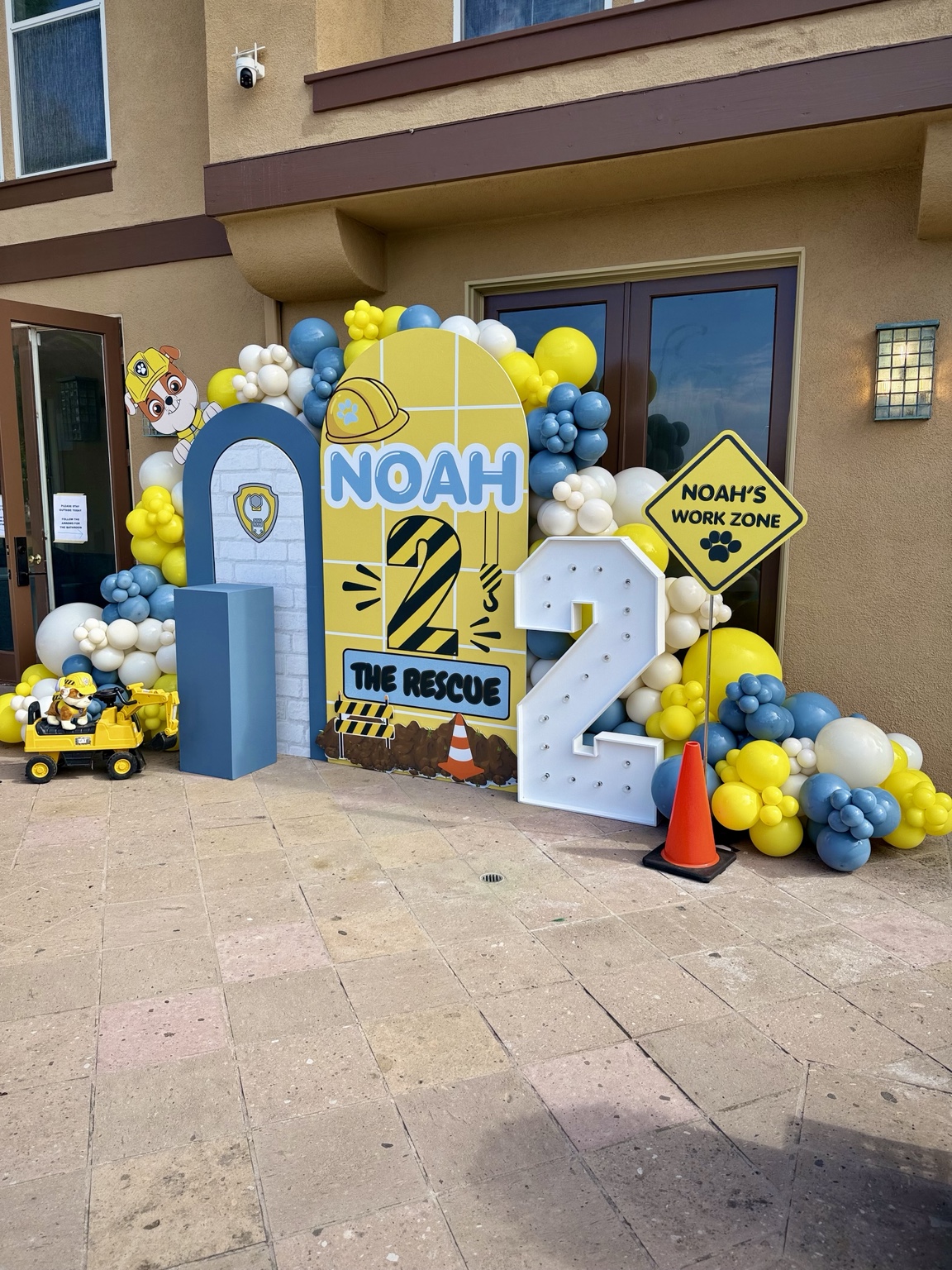 Construction themed second birthday display with custom backdrops, balloon styling, marquee number, and themed props