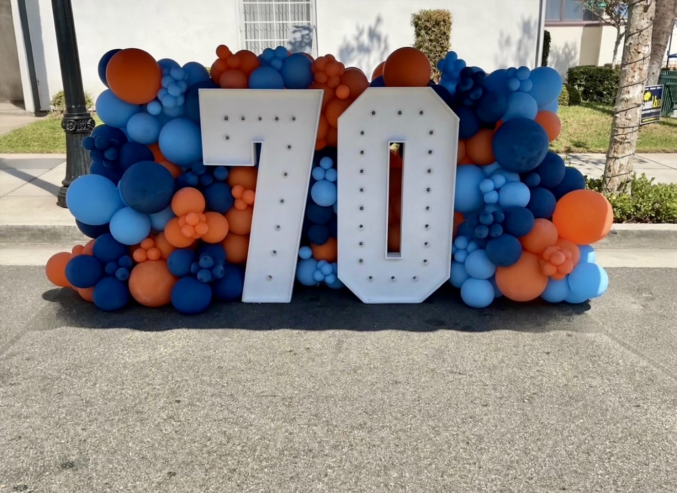 Blue and orange balloon photo display with illuminated number 70 at the Downey Festival